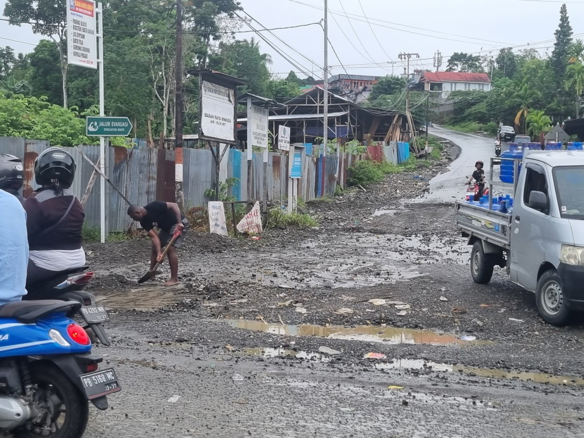 Warga Berjibaku Bersihkan Jalan Mako Brimob Tertutup Lumpur Material Drainase Akibat Hujan Lebat