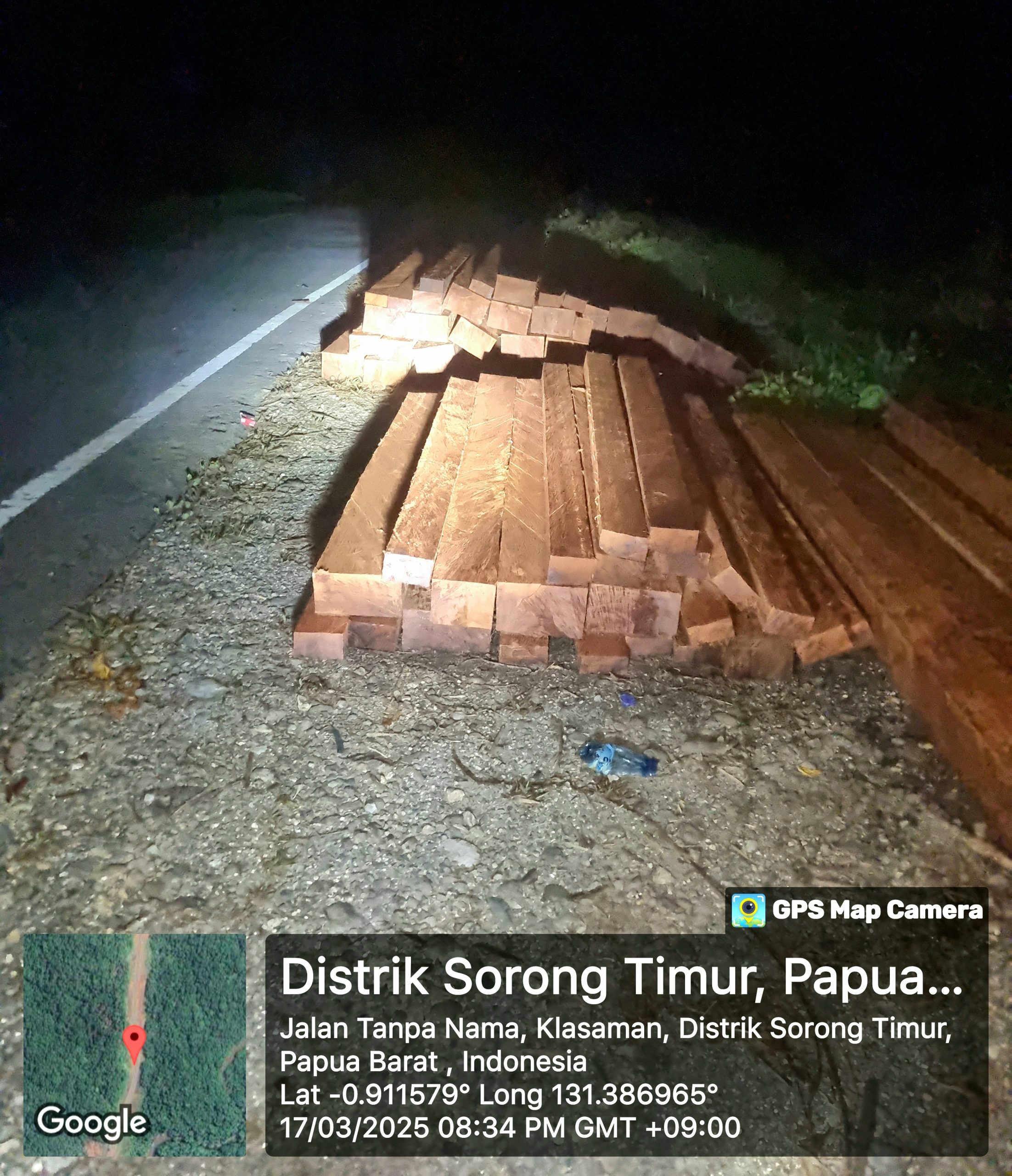 "Kayu ilegal di pinggir jalan Sorong Timur, Papua Barat, malam hari."