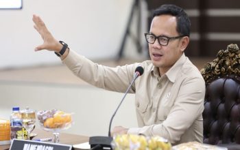 Seorang pejabat Kementerian Dalam Negeri (Kemendagri) sedang memberikan pernyataan kepada wartawan terkait larangan pengangkatan tenaga honorer baru oleh pemerintah daerah, dengan latar belakang suasana konferensi pers di Jakarta.