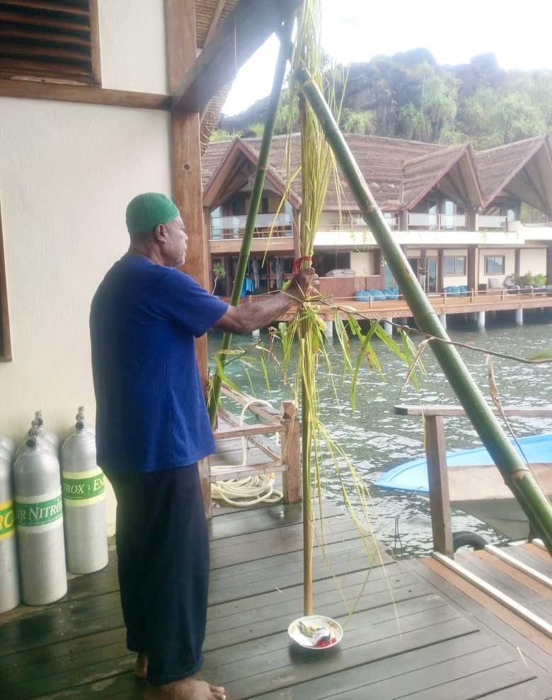 warga adat di Misool Selatan tengah memasang batang bambu dan daun kelapa sebagai simbol pemalangan di area resort, menegaskan tuntutan hak atas lahan adat.