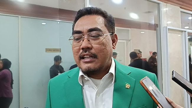 "Wakil Ketua Umum PKB Jazilul Fawaid mengenakan jas hijau sedang memberikan pernyataan kepada awak media di Gedung DPR RI."