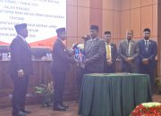 Penyerahan dokumen APBD 2026 dari Ketua DPRK Teluk Bintuni kepada Bupati Yohanes Manibuy dalam rapat paripurna DPRK